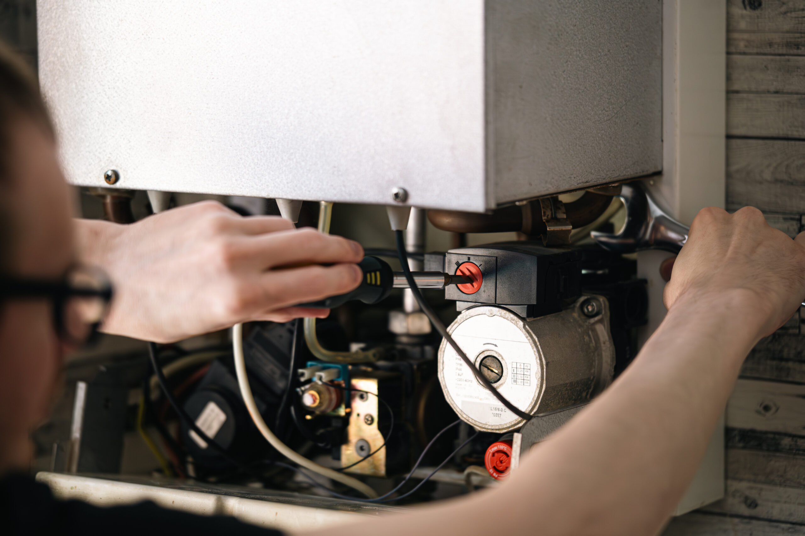Man is repairing a heating boiler