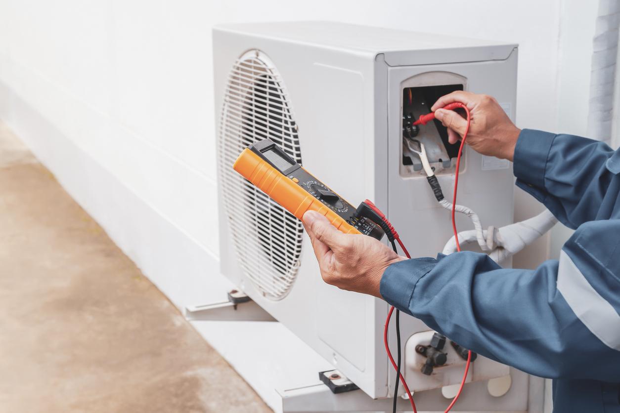 HVAC technician uses special tools to test air conditioner during tune-up